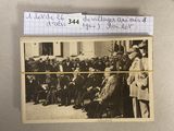 une vieille photo montrant un groupe d'hommes debout devant un bâtiment