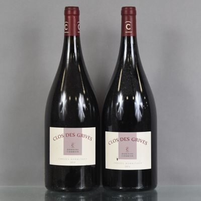 deux bouteilles de vin rouge posées sur une table en verre