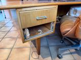 a desk with a drawer on top of it and a chair in front of it
