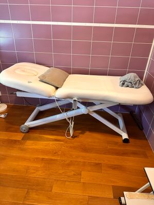 une table de massage recouverte d'une serviette, dans une pièce