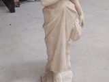 une statue représentant une femme assise sur une chaise dans une pièce