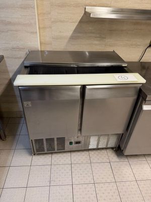 two stainless steel sinks in a kitchen with tile flooring