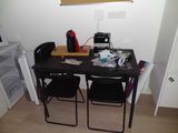 a black table with two chairs and a computer on it