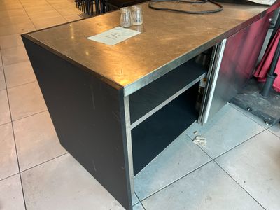 une table en métal sur laquelle est posé un verre