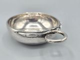 a silver bowl with a spoon in it on a table