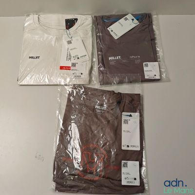 trois t-shirts et un pantalon sont posés sur une table