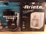 two boxes of coffee machines sitting on top of a wooden table