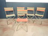 quatre chaises pliantes et une petite table dans une pièce