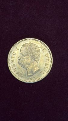 a close up of a gold coin on a black surface