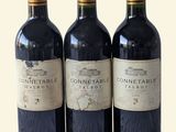 trois bouteilles de vin posées l'une à côté de l'autre sur une table