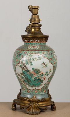 a vase with a bird on it sitting on a table