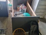 a baby crib in a room with a chair and other items