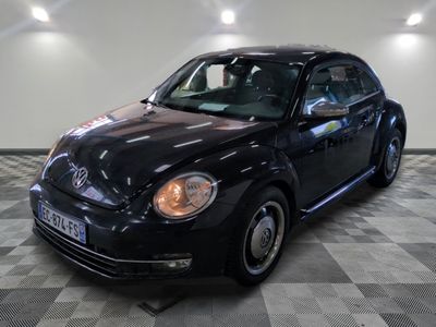 une photo d'une Coccinelle VW noire garée dans un garage