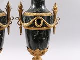 pair of black and gold vases with handles on stands