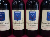 three bottles of red wine are lined up on a table