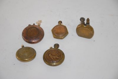 four small brass bells and a small brass bell on a white surface