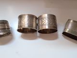 three silver napkin rings are sitting on top of a white table