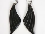 a pair of black leather earrings with silver hooks on a white background