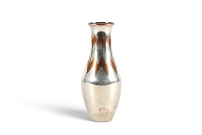 un vase en argent posé sur une surface blanche