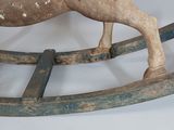 a wooden rocking horse with a long mane on a white background