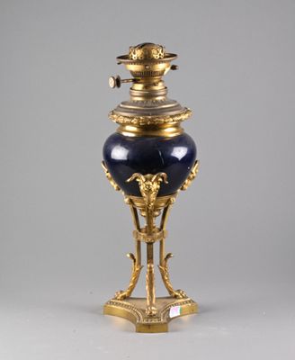 un vase bleu et or posé sur un socle, sur une surface grise