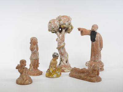 trois figurines assises l'une à côté de l'autre