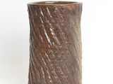 a brown vase that is sitting on a white surface