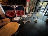 tables and chairs in a room with a large painting on the wall