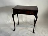 une petite table en bois avec deux tiroirs