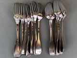 five forks and two spoons sitting on a table