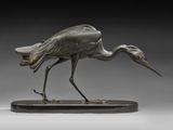 une statue en bronze représentant un oiseau au long cou et aux longues pattes