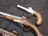 two old guns are on a black cloth with a black background