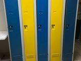 trois casiers bleus et jaunes placés les uns à côté des autres dans des toilettes