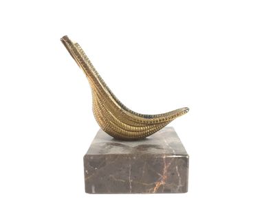 sculpture représentant une banane posée sur un socle en marbre, sur fond blanc