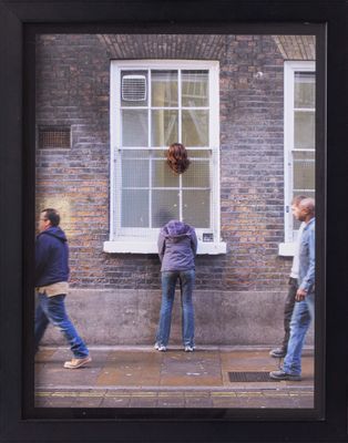people walking on the sidewalk in front of a brick building