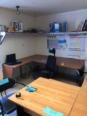 a desk with a chair and a laptop on it