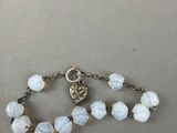 a close up of a white beaded bracelet on a table