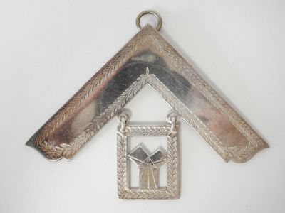 une photo d'un pendentif en forme de maison accroché à un mur