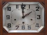 a wooden clock with black numbers on the face