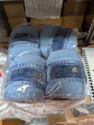 several pairs of blue slippers are wrapped in plastic on a table