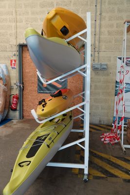 Plusieurs kayaks sont empilés les uns sur les autres dans un entrepôt