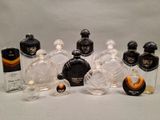 several bottles of perfume are lined up on a white surface