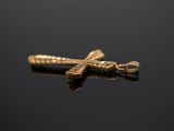 a close up of a gold cross on a black surface