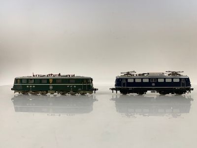 deux petits trains assis côte à côte sur une surface blanche