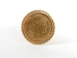 gros plan d'une pièce d'or sur une surface blanche