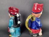 two figurines of a man and a woman sitting on a toilet