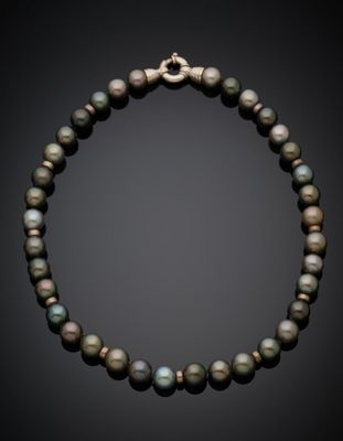 a black pearl necklace with a gold clasp on a black background