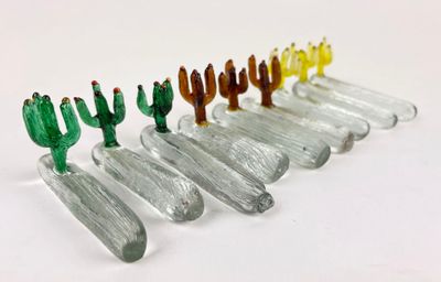 several small glass cactus figurines are lined up in a row