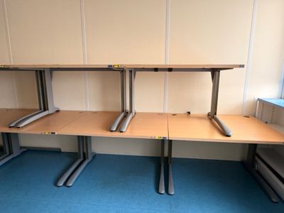 trois bureaux dans une pièce recouverte d'une moquette bleue