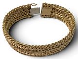 a close up of a gold bracelet on a white background